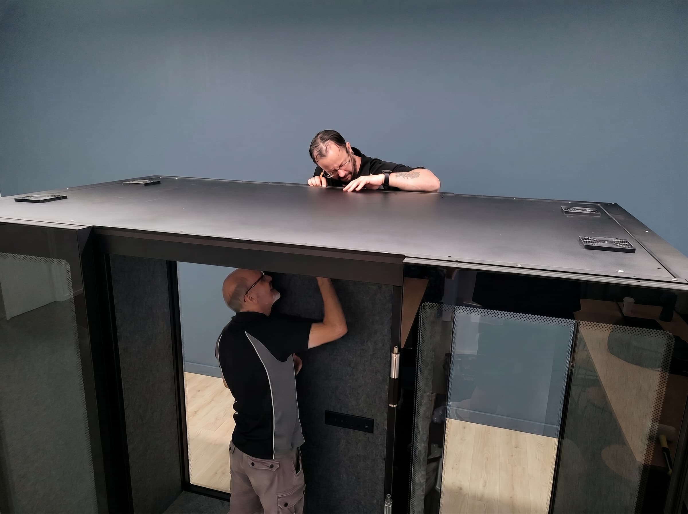 Two Peacepod installers fitting a pod together on site