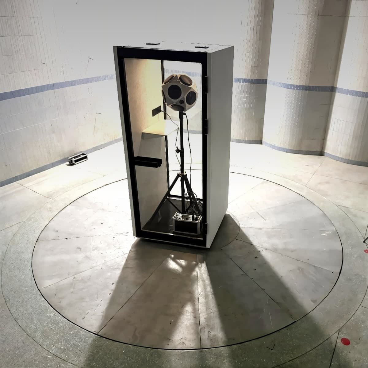 An S-Pod undergoing independent acoustic testing in a reverberation chamber — a dodecahedron source speaker inside the pod and a measurement microphone alongside