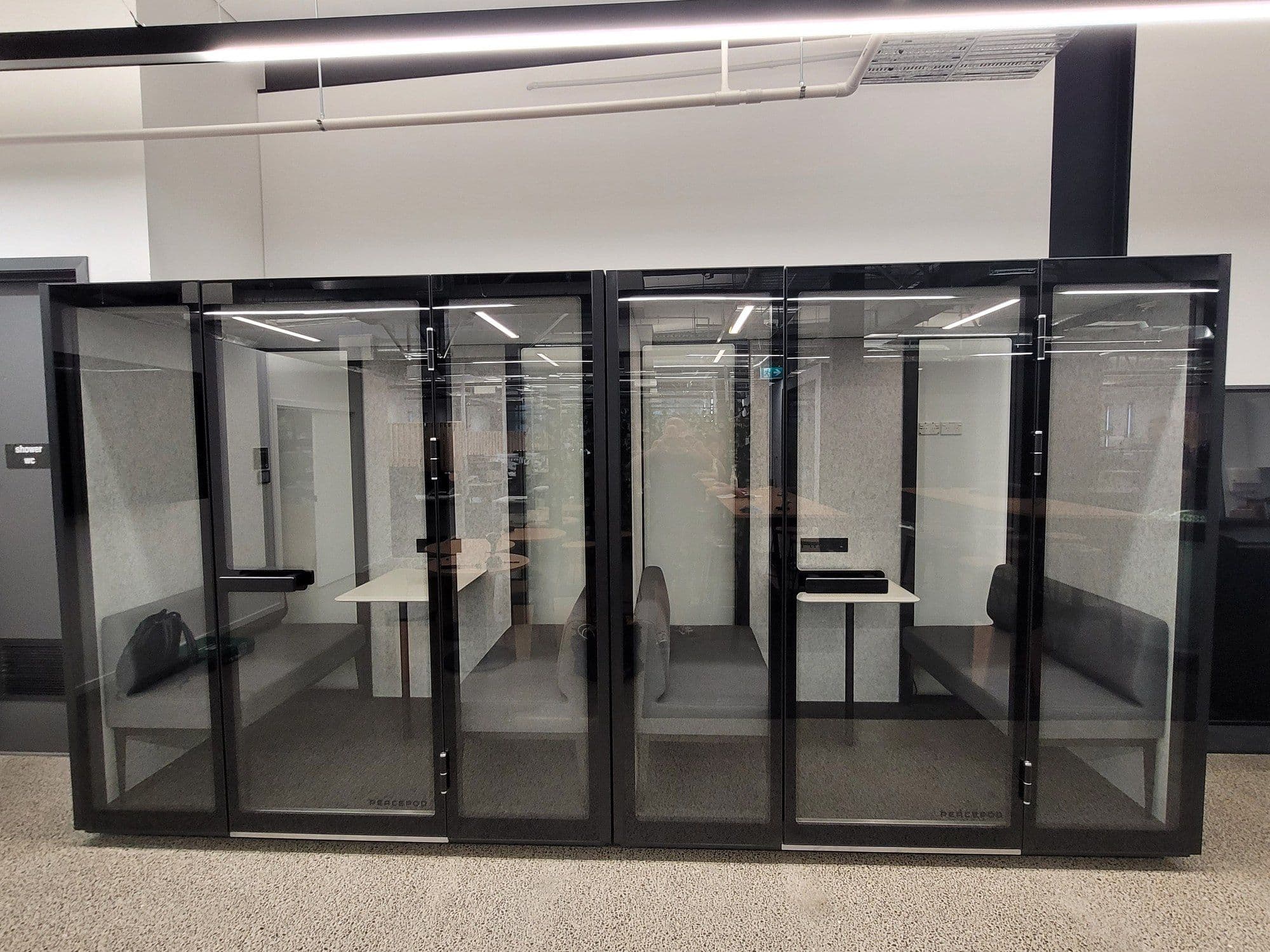 A row of Peacepods installed along an office wall