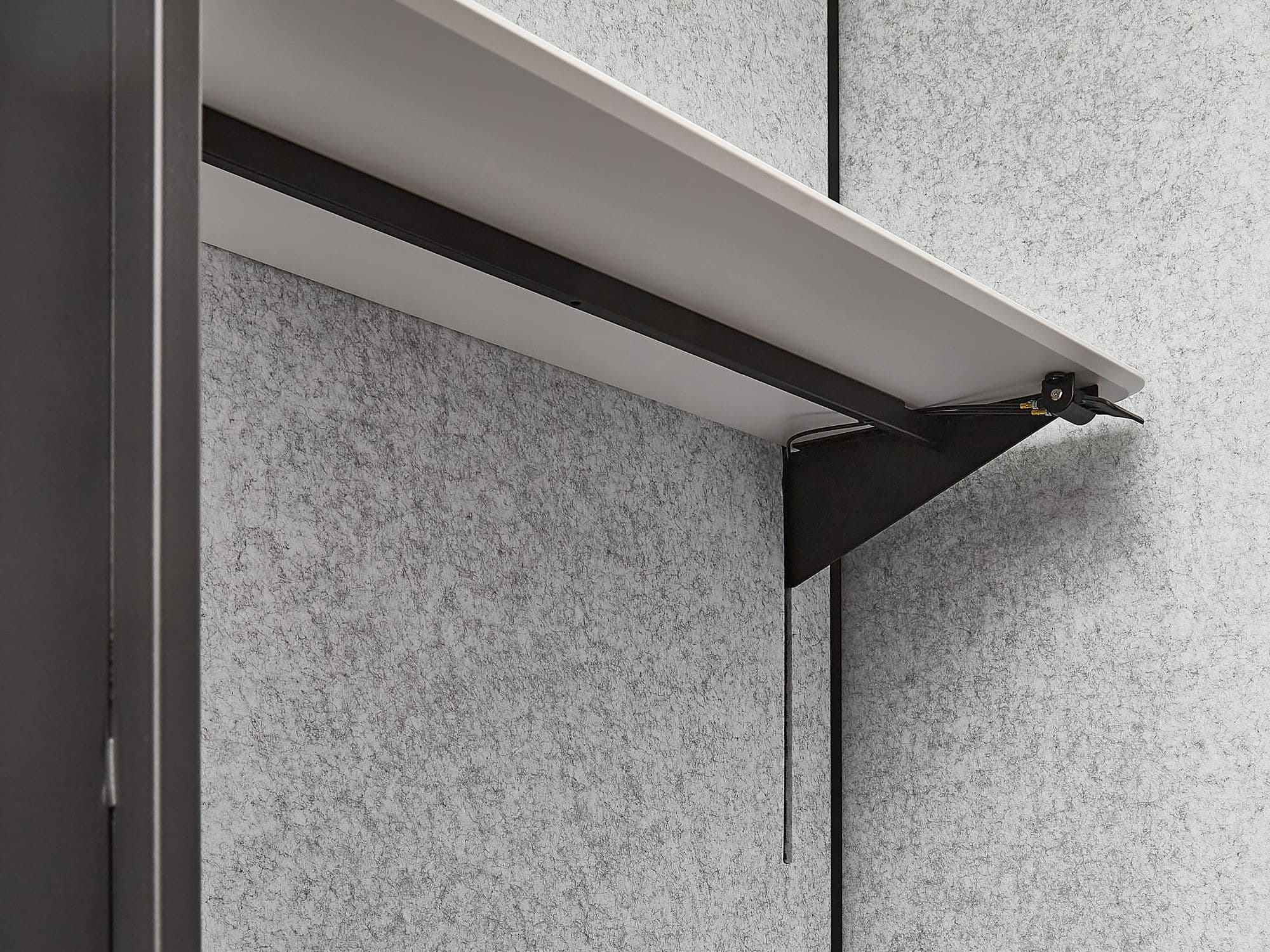 Close-up of the bracket supporting the wall-mounted sit-stand desk in an MW-Pod